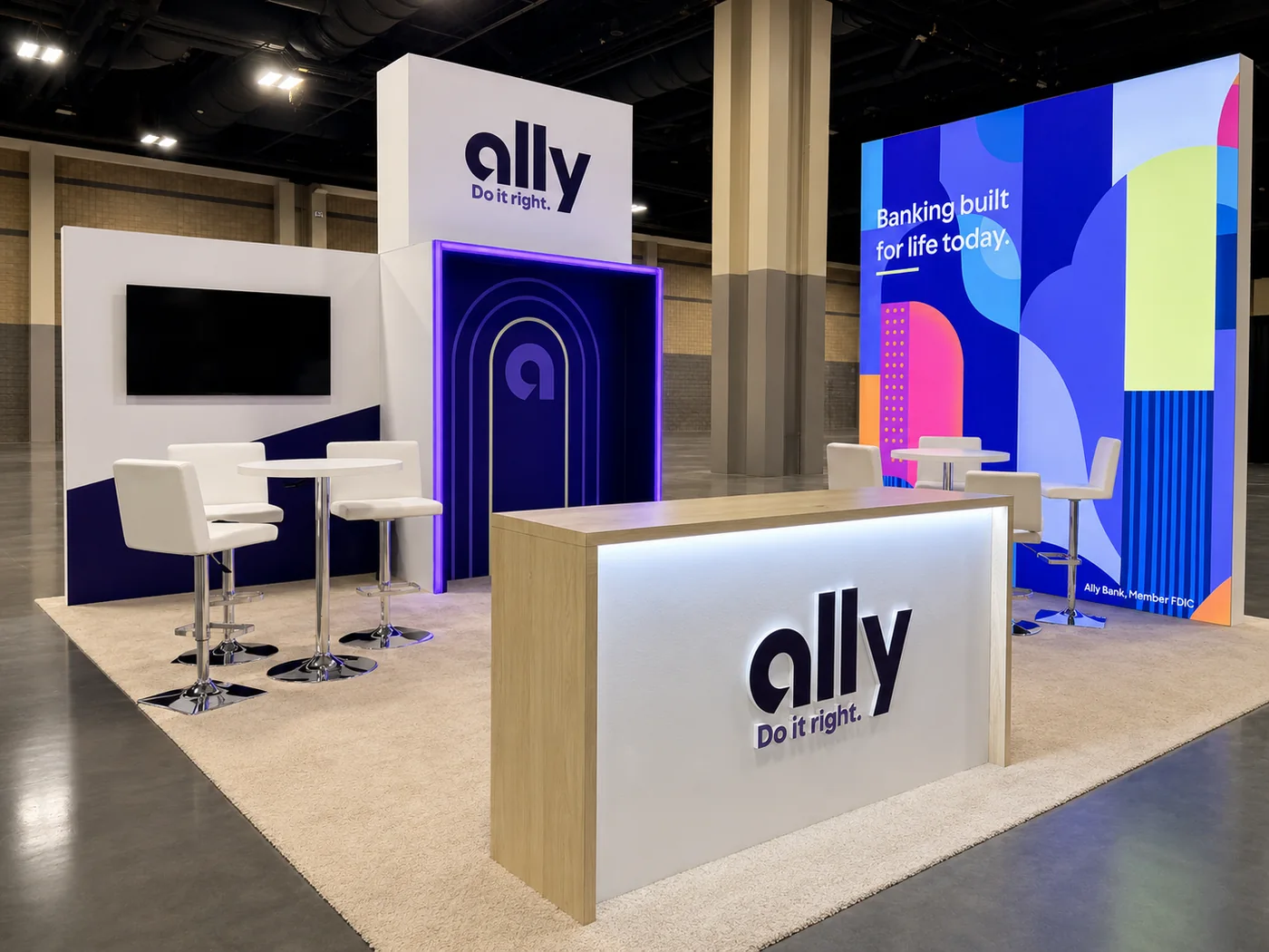 Completed Ally branded trade show exhibit with illuminated reception counter and colorful graphics