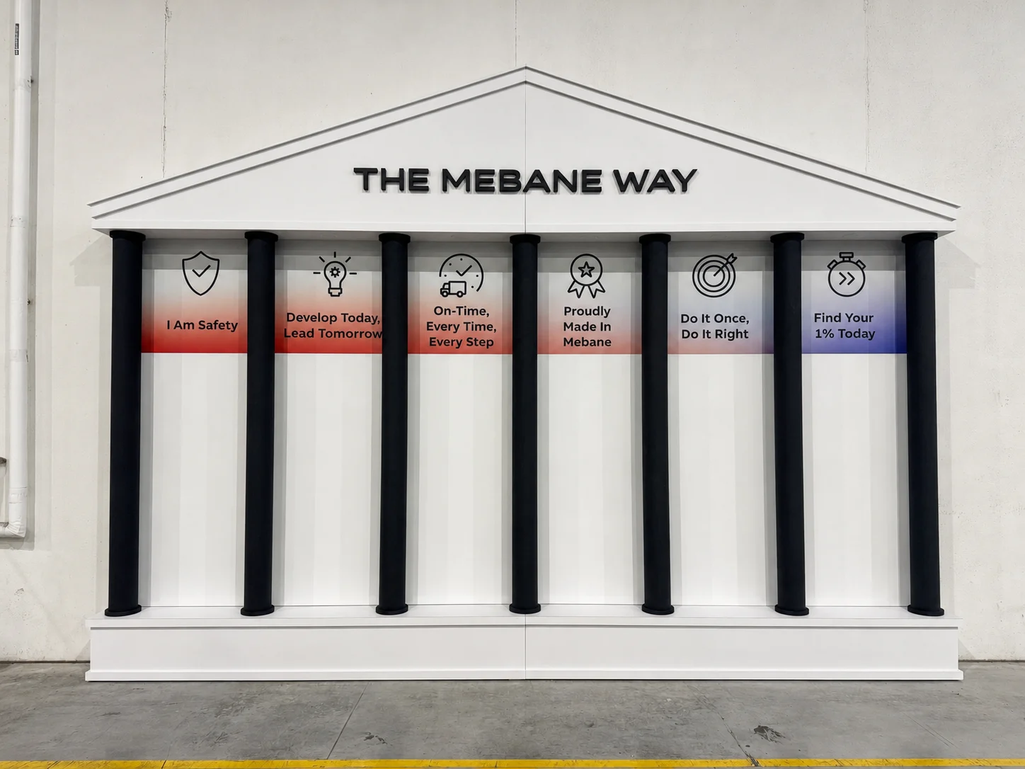 Completed permanent branded display with architectural columns, graphics, lettering, and finished presentation